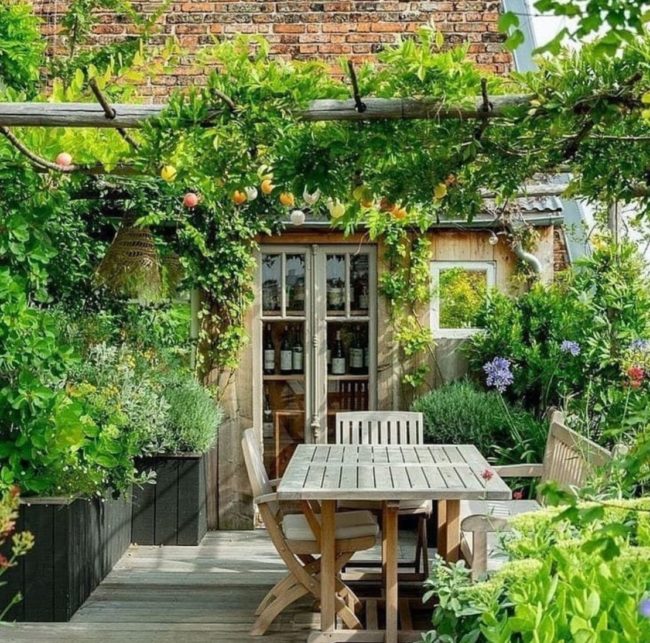 Une terrasse urbaine accueillante et vivante qui allie l'esthétique de plantes ornementales et l'utilité de plantes aromatiques et comestibles. Aménagée par un paysagiste avec des bacs sur mesure et une pergola à l'aspect naturel. Aménagement d'une terrasse Parisienne avec le paysagiste Mickaël Raillard Atelier MR.